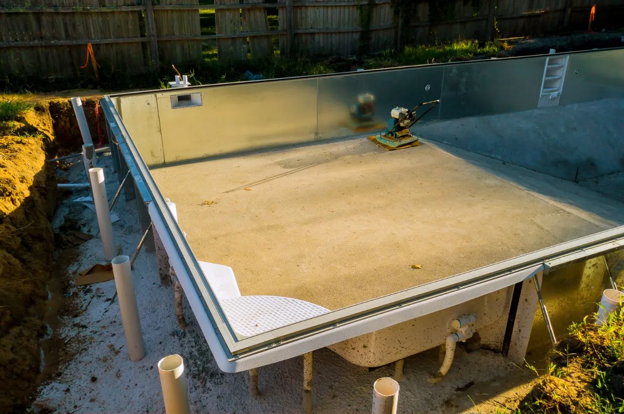 Pisciniste réalisant le terrassement d'un bassin en construction