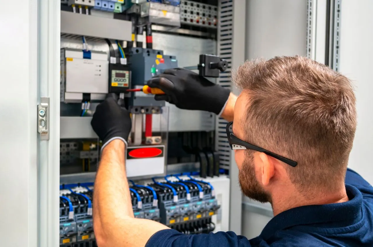 Électricien travaillant sur un tableau électrique en rénovation